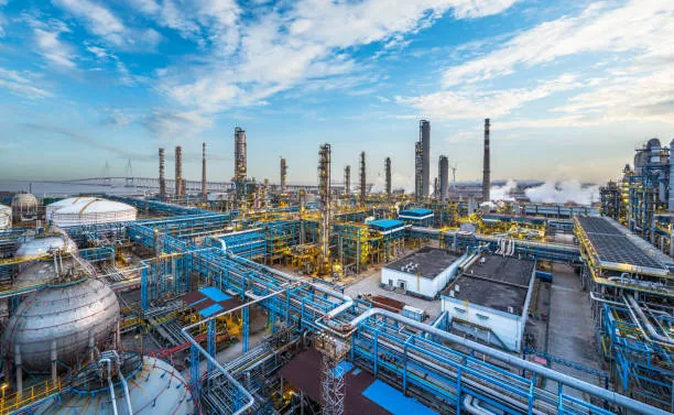 An extensive network of blue pipes, storage vessels and refinery columns